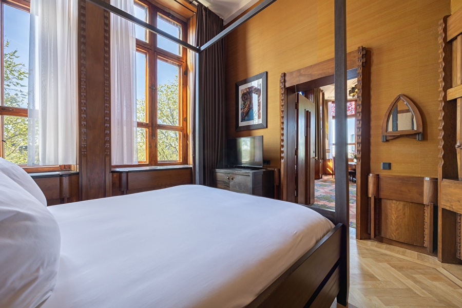 Bedroom of the Executive Suite with canopy bed, view of the canal and passage to the spacious living room.