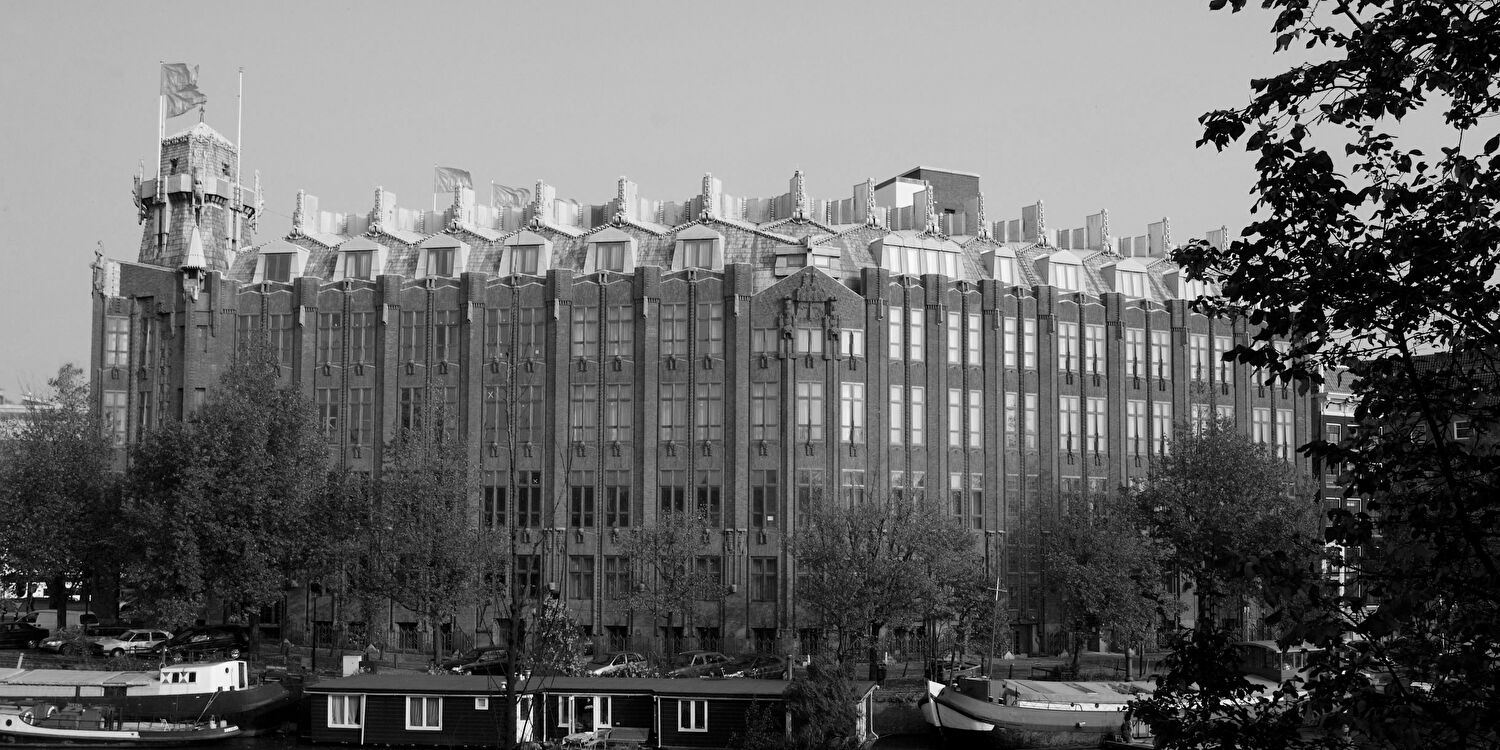 Voorgevel van Grand Hotel Amrâth Amsterdam aan het water, in het monumentale Scheepvaarthuis, een voorbeeld van de Amsterdamse School-architectuur.