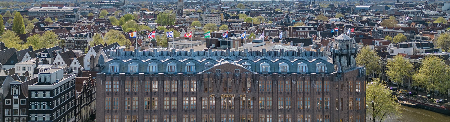 Grand Hotel Amrâth Amsterdam met stadspanorama op de achtergrond.