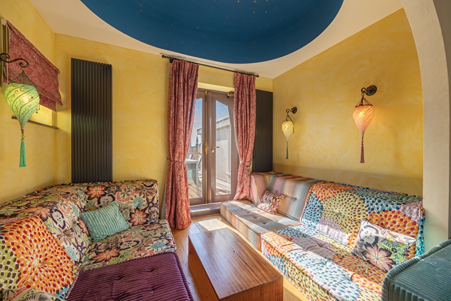 Colorful seating area in the Oriental Suite with mosaic bench, oriental lamps, and access to private terrace.