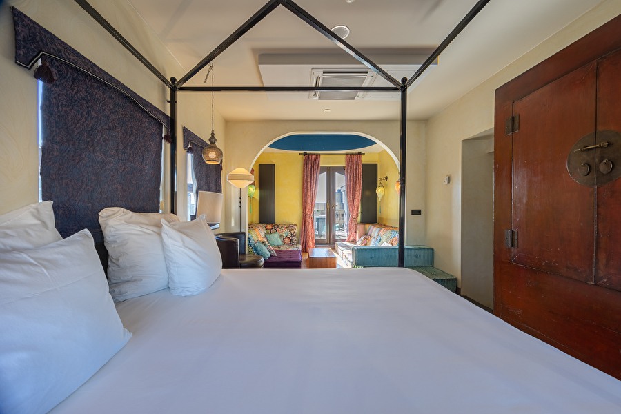 View from the bed of the Oriental Suite onto the colorful seating area with oriental accents and balcony.