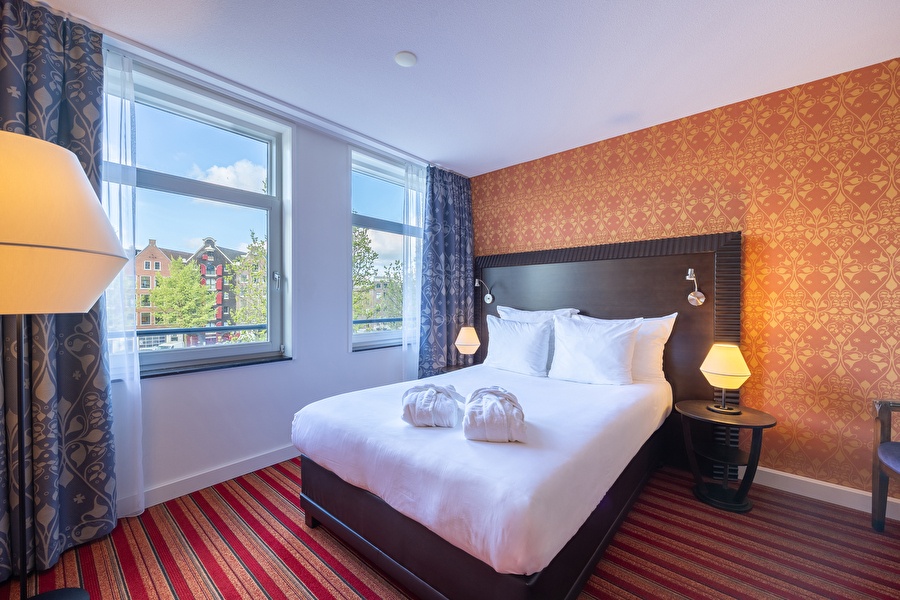 Single Room with a view over the Amsterdam canals, double bed and warm tones.