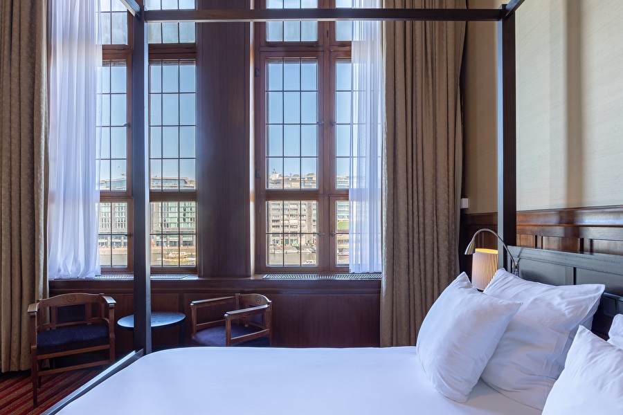 Detail of the four-poster bed in the Suite with views over the Oosterdok through high stained glass windows.