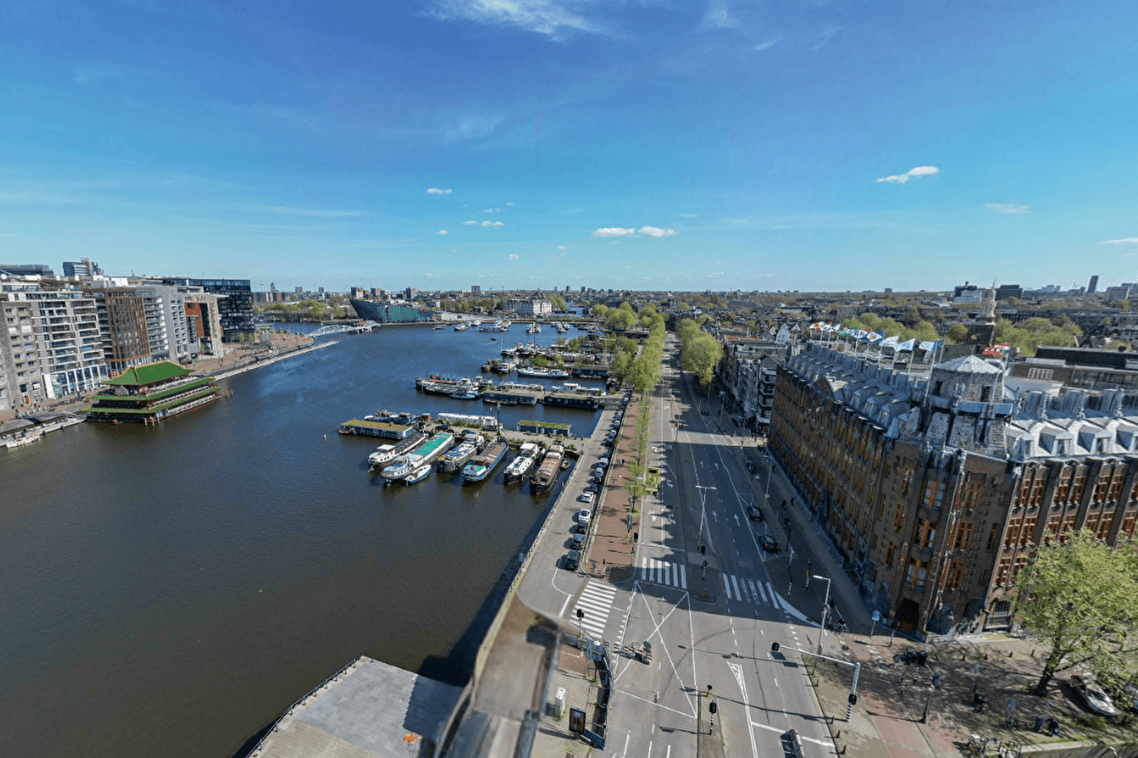 Executive Suite in Grand Hotel Amrâth Amsterdam met kleurrijk tapijt, art-decostijl meubilair en grote ramen met uitzicht op het Oosterdok
